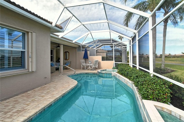 view of swimming pool with a lanai, an in ground hot tub, and a patio