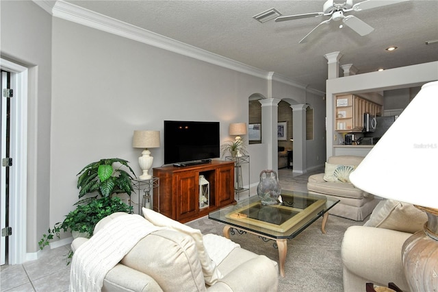 living room with ornate columns, crown molding, light tile patterned floors, and a textured ceiling