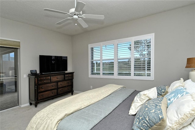 carpeted bedroom featuring ceiling fan and a textured ceiling