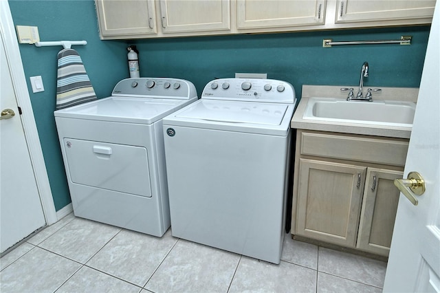 laundry room featuring sink, light tile patterned floors, cabinets, and independent washer and dryer