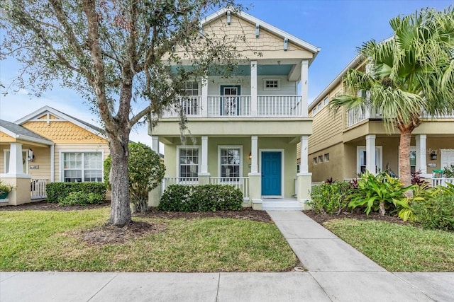 view of front of house with a balcony and a front lawn