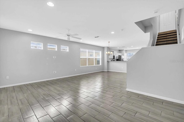 interior space featuring ceiling fan with notable chandelier