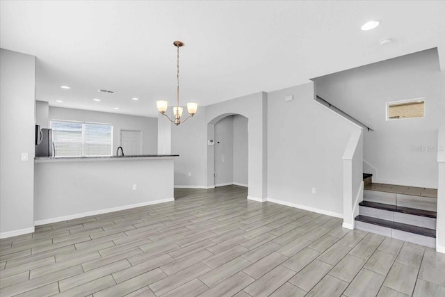 unfurnished living room with a chandelier and sink