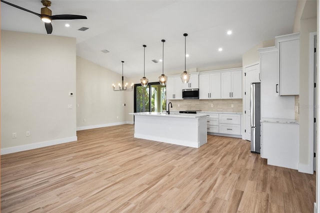 kitchen featuring decorative light fixtures, white cabinetry, vaulted ceiling, ceiling fan, and appliances with stainless steel finishes