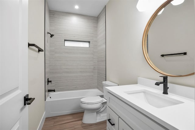 full bathroom with toilet, hardwood / wood-style floors, vanity, and tiled shower / bath combo