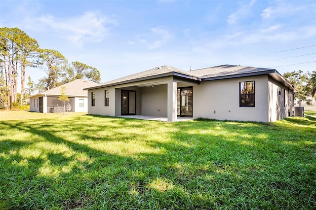 rear view of property with a yard, a patio, and central AC unit