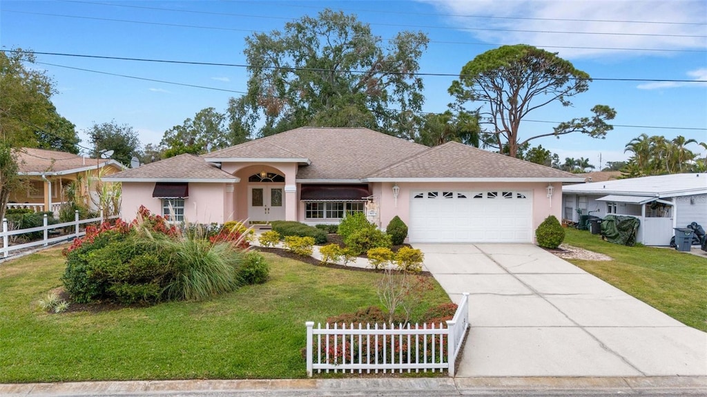 ranch-style home featuring a garage and a front lawn