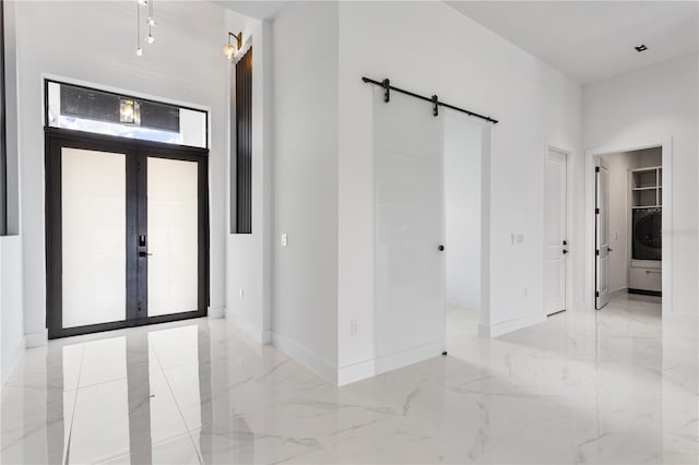 entrance foyer with washer / clothes dryer, french doors, and a barn door