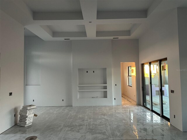 unfurnished living room featuring coffered ceiling, a towering ceiling, and built in features