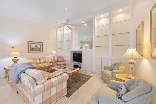 living room with built in shelves and ceiling fan