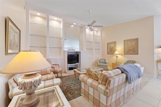 tiled living room with ceiling fan and built in features