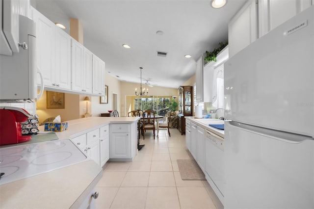 kitchen featuring pendant lighting, white appliances, kitchen peninsula, vaulted ceiling, and white cabinetry