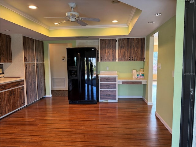 kitchen with a tray ceiling, ceiling fan, black fridge with ice dispenser, and dark hardwood / wood-style floors