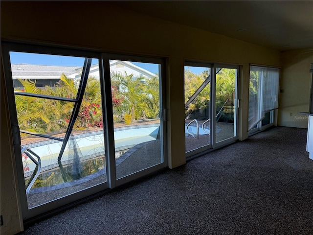 doorway to outside with dark colored carpet