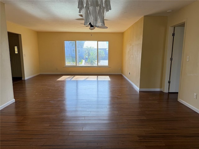 unfurnished room with dark hardwood / wood-style flooring and ceiling fan