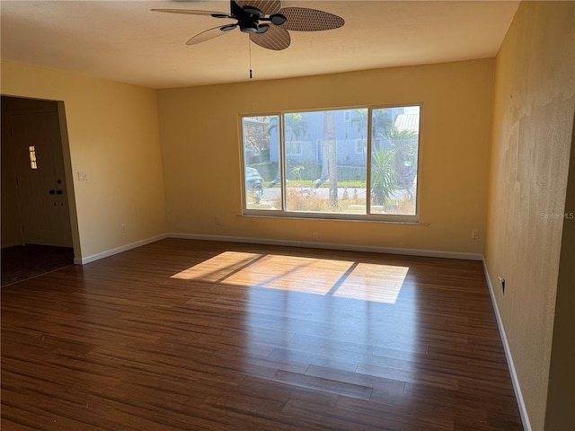 empty room featuring ceiling fan and dark wood-type flooring