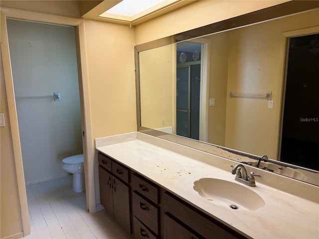 bathroom featuring a skylight, vanity, and toilet