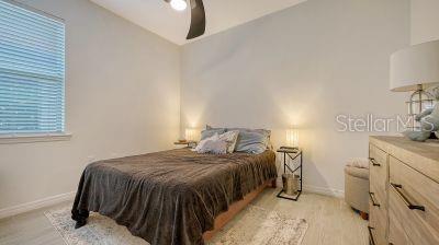 bedroom with vaulted ceiling, light hardwood / wood-style flooring, and ceiling fan