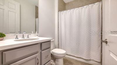 bathroom featuring a shower with curtain, vanity, and toilet