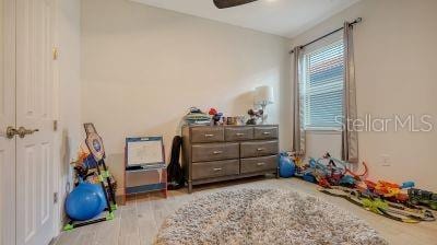 playroom with light hardwood / wood-style flooring and ceiling fan