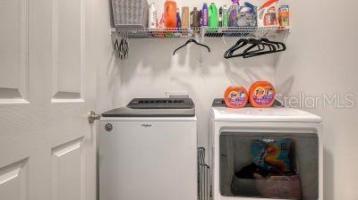 clothes washing area with washer and clothes dryer