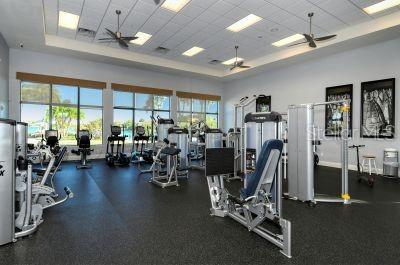 gym featuring a wealth of natural light, a paneled ceiling, and ceiling fan