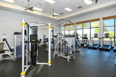 gym featuring a drop ceiling and ceiling fan