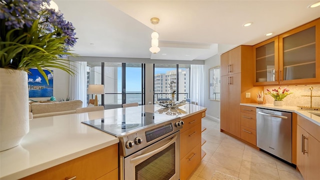 kitchen with pendant lighting, stove, a water view, stainless steel dishwasher, and light tile patterned floors