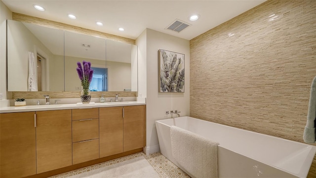 bathroom featuring tile patterned floors, vanity, and a tub