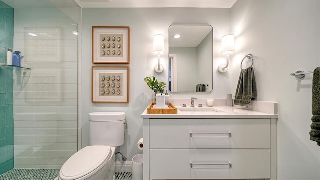 bathroom with vanity, toilet, and a tile shower