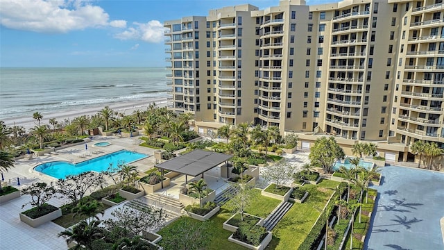 birds eye view of property featuring a water view and a beach view