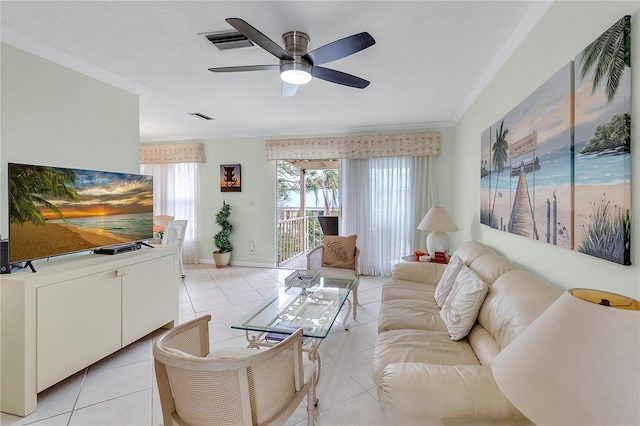 living room featuring light tile patterned floors, a textured ceiling, ceiling fan, and ornamental molding