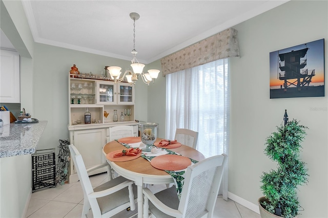 tiled dining area with an inviting chandelier and ornamental molding