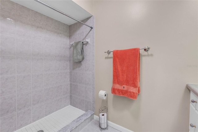 bathroom with tile patterned floors, vanity, and tiled shower