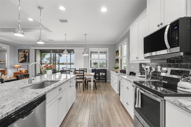 kitchen featuring sink, white cabinets, stainless steel appliances, and ornamental molding