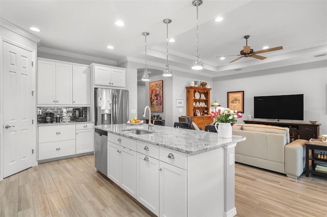 kitchen with white cabinets, sink, an island with sink, appliances with stainless steel finishes, and decorative light fixtures