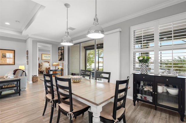 dining space with light wood-type flooring and ornamental molding