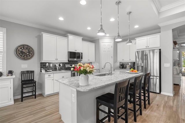 kitchen with backsplash, sink, white cabinets, and appliances with stainless steel finishes