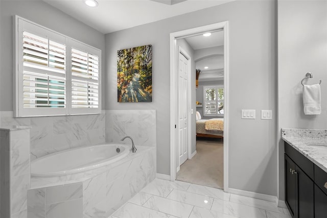 bathroom with vanity and a relaxing tiled tub