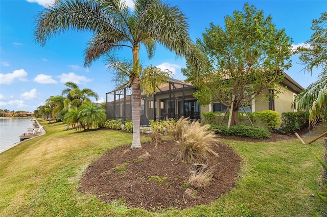 view of yard featuring a lanai and a water view