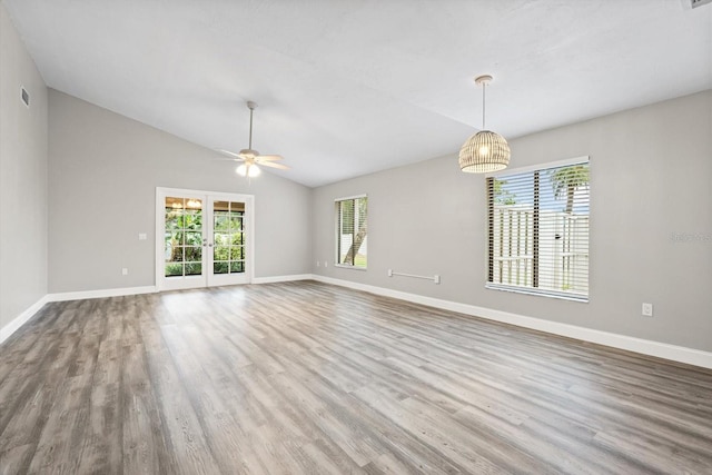 spare room with ceiling fan, french doors, hardwood / wood-style floors, and vaulted ceiling