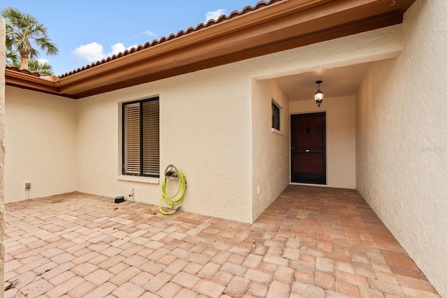 view of exterior entry with a patio