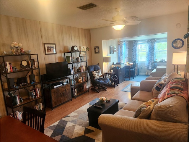 living room with ceiling fan and light wood-type flooring