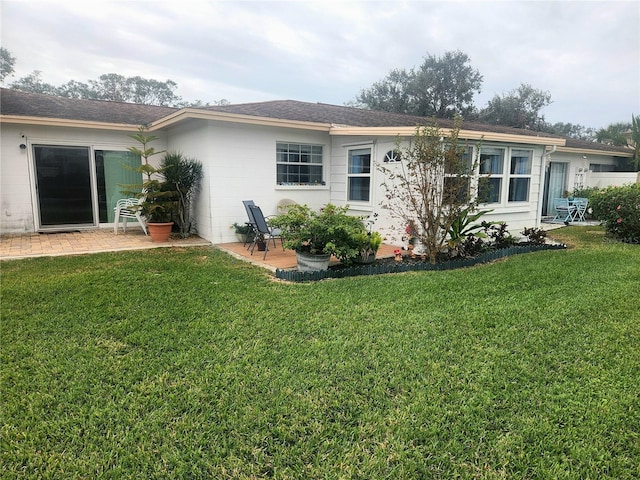 rear view of property featuring a yard and a patio