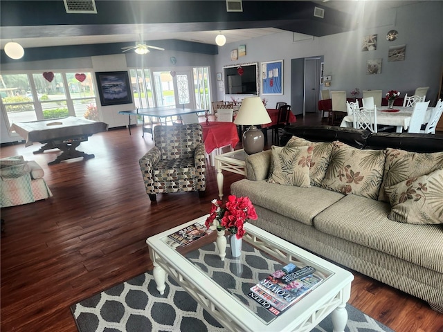 living room featuring beamed ceiling, a wealth of natural light, dark wood-type flooring, and ceiling fan