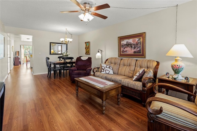 living room featuring ceiling fan with notable chandelier, a textured ceiling, and hardwood / wood-style flooring