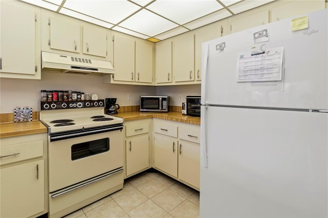 kitchen featuring white appliances, cream cabinets, and light tile patterned floors