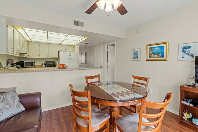 dining area featuring ceiling fan and dark wood-type flooring