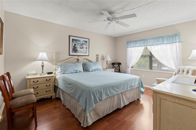 bedroom featuring dark wood-type flooring, a textured ceiling, and ceiling fan