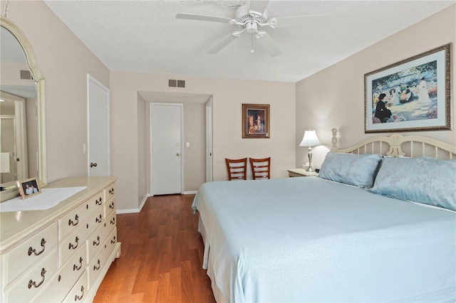 bedroom featuring hardwood / wood-style flooring, a textured ceiling, and ceiling fan